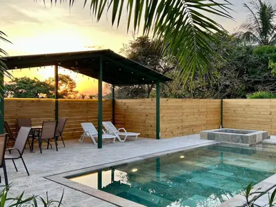 a swimming pool with a patio with a table and chairs at Casa Blanca Manuel Antonio B1, Central, Pool, Gated in Manuel Antonio