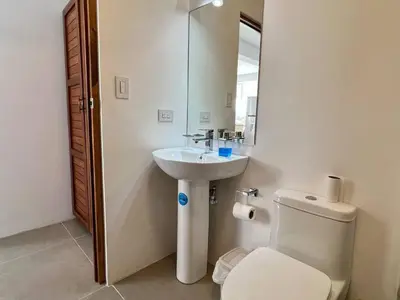a bathroom with a sink and a toilet and a mirror at Casa Blanca Manuel Antonio B1, Central, Pool, Gated in Manuel Antonio