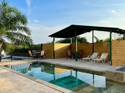 a patio with chairs and a pavilion next to a pool at Casa Blanca Manuel Antonio B1, Central, Pool, Gated in Manuel Antonio