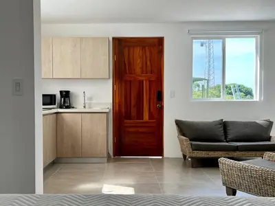 a living room with a red door and a couch at Casa Blanca Manuel Antonio B1, Central, Pool, Gated in Manuel Antonio