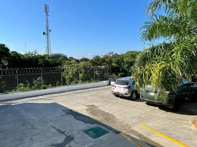 two cars parked in a parking lot with palm trees at Casa Blanca Manuel Antonio A2, Central, Pool, Gated in Manuel Antonio