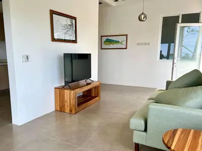 a living room with a television and a couch at Casa Blanca Manuel Antonio A2, Central, Pool, Gated in Manuel Antonio