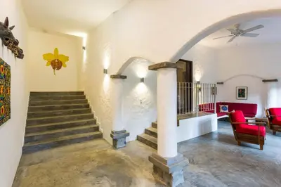a living room with a staircase and a ceiling fan at Villa Lapas, Central, Spacious and Lots of Wildlife in Manuel Antonio