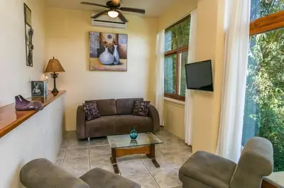 a living room with a couch and a tv at Castillo de Amber, 4 Aparts, 6 Bedrooms, Ocean Views, Central Location in Manuel Antonio