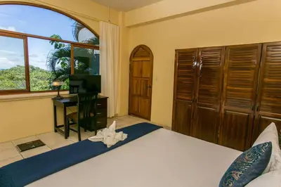 a bedroom with a bed and a desk and a window at Castillo de Amber, 4 Aparts, 6 Bedrooms, Ocean Views, Central Location in Manuel Antonio
