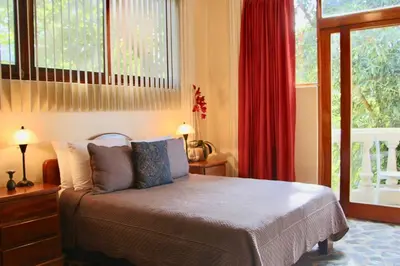 a bedroom with a bed with pillows and windows at Castillo de Amber, 4 Aparts, 6 Bedrooms, Ocean Views, Central Location in Manuel Antonio