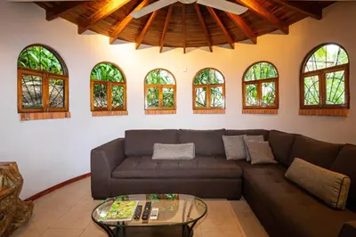 a living room with a couch and a table at Villa Monos, 2BR Home, 1BR Guest House and Pool in Manuel Antonio