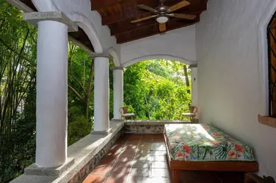 a porch of a house with a ceiling fan at Villa Monos, 2BR Home, 1BR Guest House and Pool in Manuel Antonio