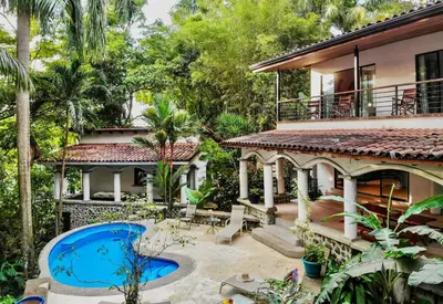 an exterior view of a house with a swimming pool at Villa Monos, 2BR Home, 1BR Guest House and Pool in Manuel Antonio