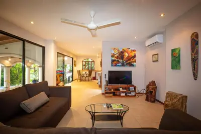 a living room with a couch and a tv at Villa Monos, 2BR Home, 1BR Guest House and Pool in Manuel Antonio