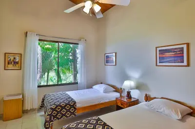 a bedroom with two beds and a window at Casa Kilimanjaro Nature, Amazing Views and 6 Acres in Manuel Antonio