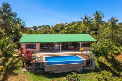 a house with a swimming pool in front of it at Casa Kilimanjaro Nature, Amazing Views and 6 Acres in Manuel Antonio