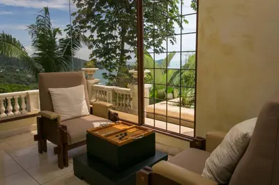 a living room with a view of a balcony at Villa Vigia, beach views, 3 acres of privacy and tons of wildlife in Manuel Antonio