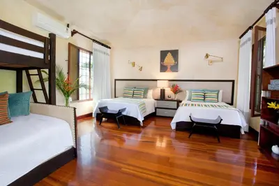 a bedroom with two beds and a wooden floor at Villa Vigia, beach views, 3 acres of privacy and tons of wildlife in Manuel Antonio