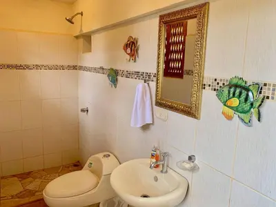 a bathroom with a sink and a toilet and a mirror at El Perezoso, Studio Apartment w Views and Central Location in Manuel Antonio