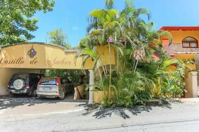 a car parked in front of a building with palm trees at El Perezoso, Studio Apartment w Views and Central Location in Manuel Antonio