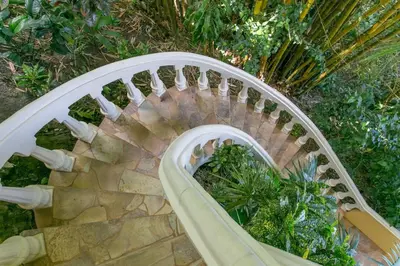 a spiral staircase in a garden with plants at El Perezoso, Studio Apartment w Views and Central Location in Manuel Antonio