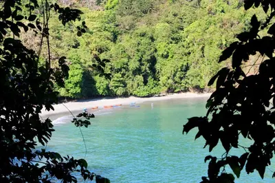 a view of a beach with people in the water at El Perezoso, Studio Apartment w Views and Central Location in Manuel Antonio