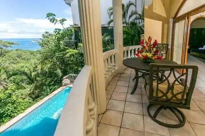 a balcony with a table and a pool at El Titi, 1 Bedroom Ocean View Apartment, Central Location in Manuel Antonio