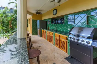 a kitchen with green walls and a stove at El Congo, 2BR Apartment w Great Ocean Views and Central Location in Manuel Antonio