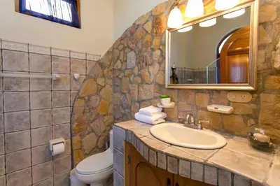 a bathroom with a sink and a toilet and a mirror at El Capuchin, 2BR Ocean View Apartment, Central Location in Manuel Antonio