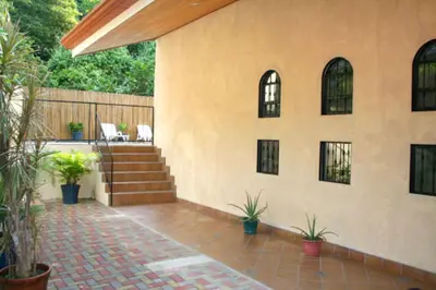 a patio with potted plants on the side of a house at Casa Sophia A Cozy, Treetop, Sea View Gem in Quepos
