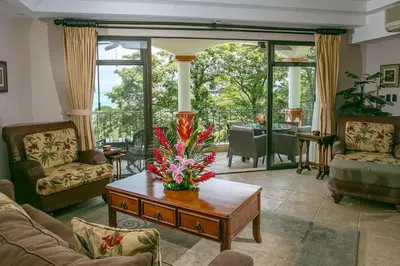 a living room with a table with flowers on it at Shana Residences 310 Sea View Condo Walk to beach in Manuel Antonio