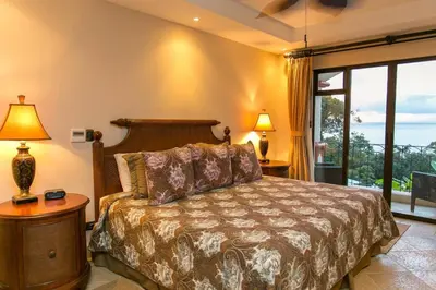 a bedroom with a bed and a large window at Shana Residences 310 Sea View Condo Walk to beach in Manuel Antonio