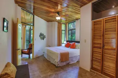 a bedroom with a bed in a room with windows at Jungle Creek all 4 villas up to 19 people in Manuel Antonio