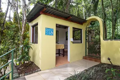a small yellow house with a sign that reads black bay at Jungle Creek all 4 villas up to 19 people in Manuel Antonio