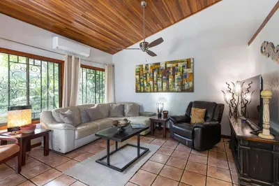 a living room with a couch and a chair at Jungle Creek all 4 villas up to 19 people in Manuel Antonio