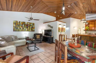 a living room with a couch and a table at Jungle Creek all 4 villas up to 19 people in Manuel Antonio