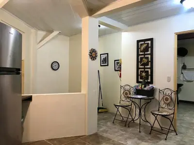 a room with chairs and a table and a clock on the wall at Mono Vista At Jungle Creek Chill out in the Jungle in Manuel Antonio