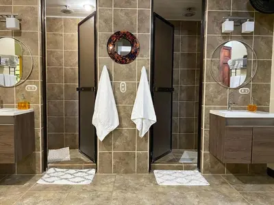 a bathroom with two sinks and two mirrors at Mono Vista At Jungle Creek Chill out in the Jungle in Manuel Antonio