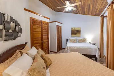a bedroom with two beds and a ceiling fan at Alma Pacifica, Charming, secure and lots of wildlife in Manuel Antonio