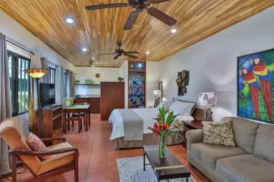 a bedroom with a bed and a living room at El Gekko spacious studio in Manuel Antonio