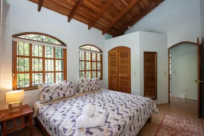 a bedroom with a large bed with a statue on it at Casa Pura Vida Manuel Antonio in Manuel Antonio