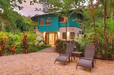 a house with chairs in front of it at Casa Pura Vida Manuel Antonio in Manuel Antonio