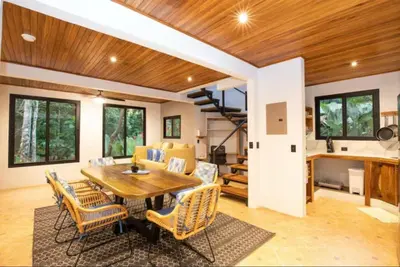 a dining room with a wooden table and chairs at Casa Pura Vida Manuel Antonio in Manuel Antonio