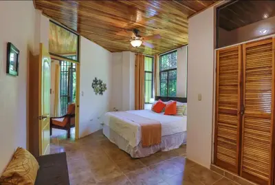 a bedroom with a bed with orange pillows in it at Dos Palmas1200sqft 1King 1Queen,AC,WiFi,Pool,Gated in Manuel Antonio