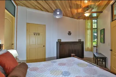 a bedroom with a bed with a wooden ceiling at Dos Palmas1200sqft 1King 1Queen,AC,WiFi,Pool,Gated in Manuel Antonio