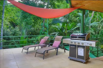 a patio with a stove and chairs and a grill at Dos Palmas1200sqft 1King 1Queen,AC,WiFi,Pool,Gated in Manuel Antonio