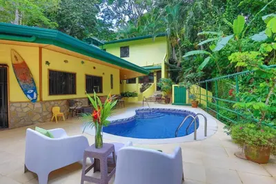 a house with a swimming pool in the yard at Dos Palmas1200sqft 1King 1Queen,AC,WiFi,Pool,Gated in Manuel Antonio