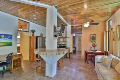 a kitchen and living room with a table in a room at Dos Palmas1200sqft 1King 1Queen,AC,WiFi,Pool,Gated in Manuel Antonio