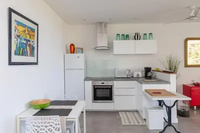 a kitchen with white appliances and a table in it at Monteverde, 1 Bedroom Apartment in La Maison Blanche, Nature in Manuel Antonio