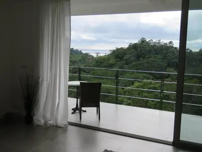 a room with a balcony with a table and a window at Monteverde, 1 Bedroom Apartment in La Maison Blanche, Nature in Manuel Antonio