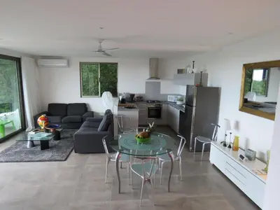 a kitchen and a living room with a table and chairs at Guanacaste, 2 Bedroom Apartment in La Maison Blanche in Manuel Antonio