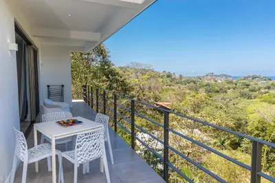 a balcony with a table and chairs and a view at Guanacaste, 2 Bedroom Apartment in La Maison Blanche in Manuel Antonio