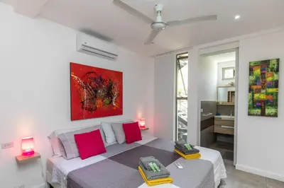 a bedroom with a bed and a painting on the wall at Guanacaste, 2 Bedroom Apartment in La Maison Blanche in Manuel Antonio