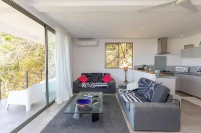 a living room with two couches and a table at Guanacaste, 2 Bedroom Apartment in La Maison Blanche in Manuel Antonio